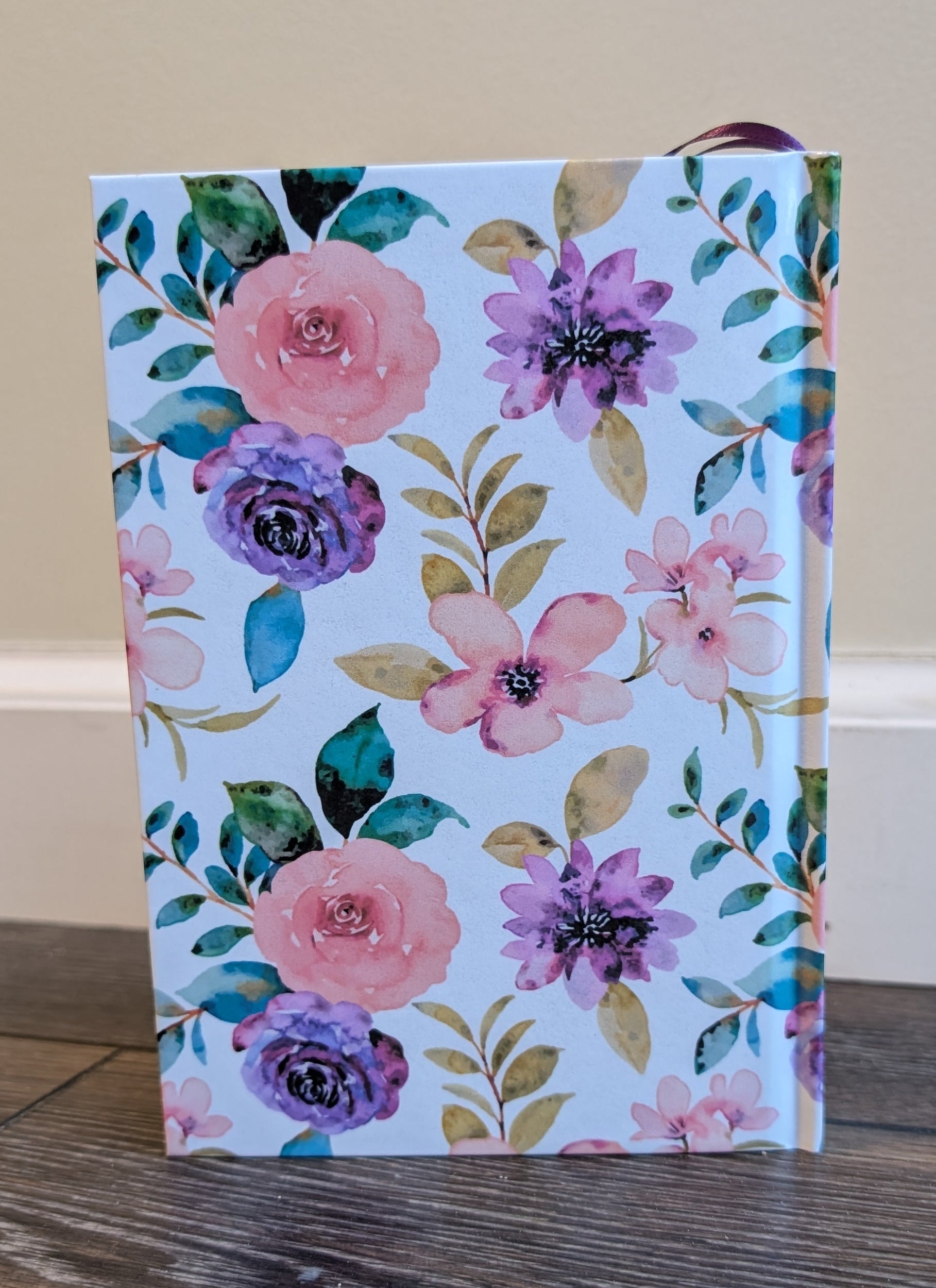 Floral-patterned box on a wooden surface with a neutral background
