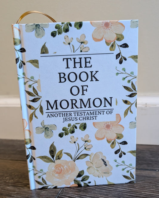 Book of Mormon with floral design on a wooden surface