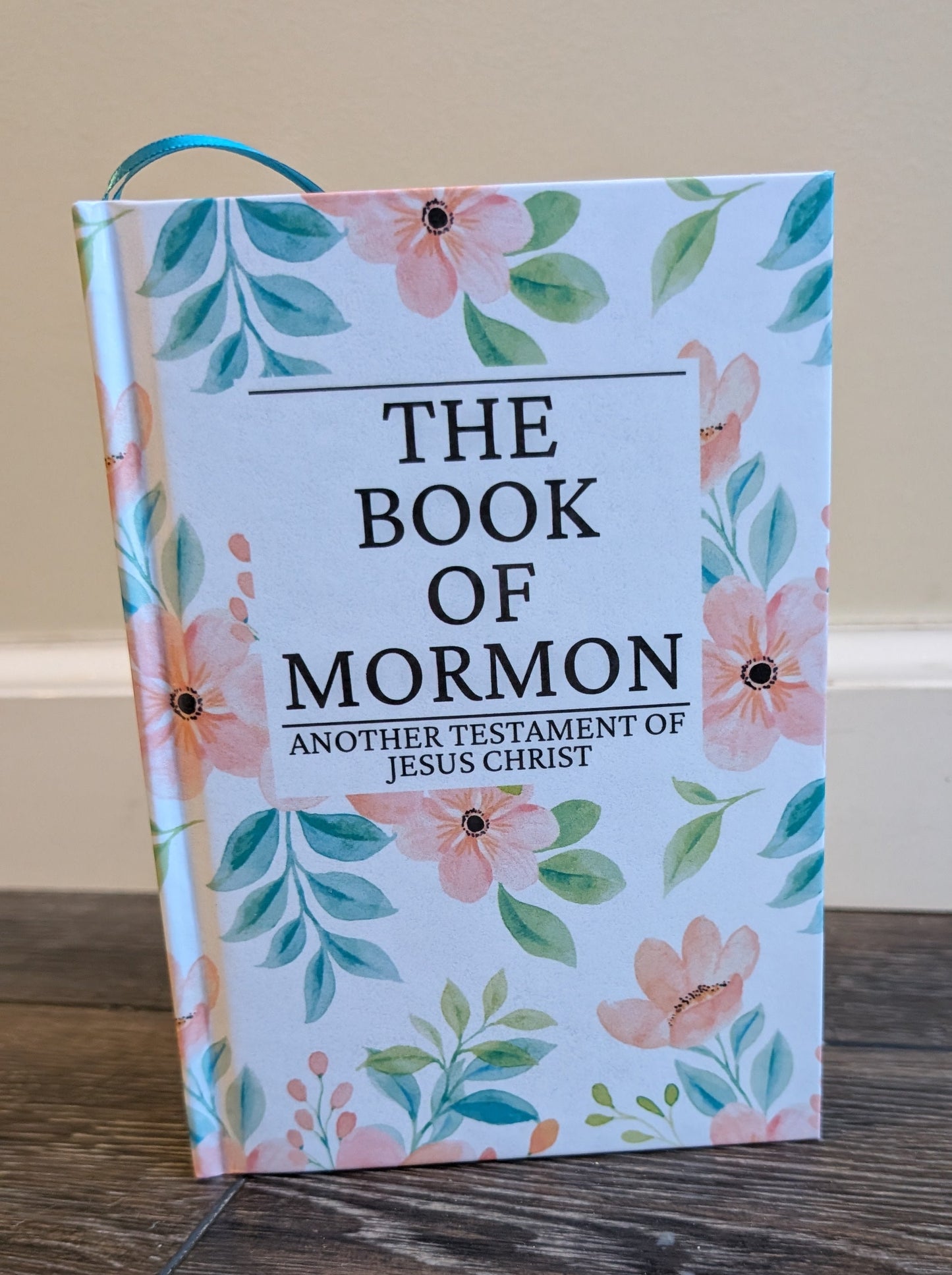 Book of Mormon with floral design on a wooden surface