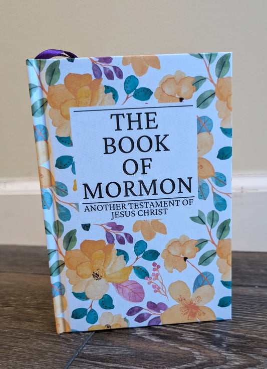 Book of Mormon with floral design on a wooden surface