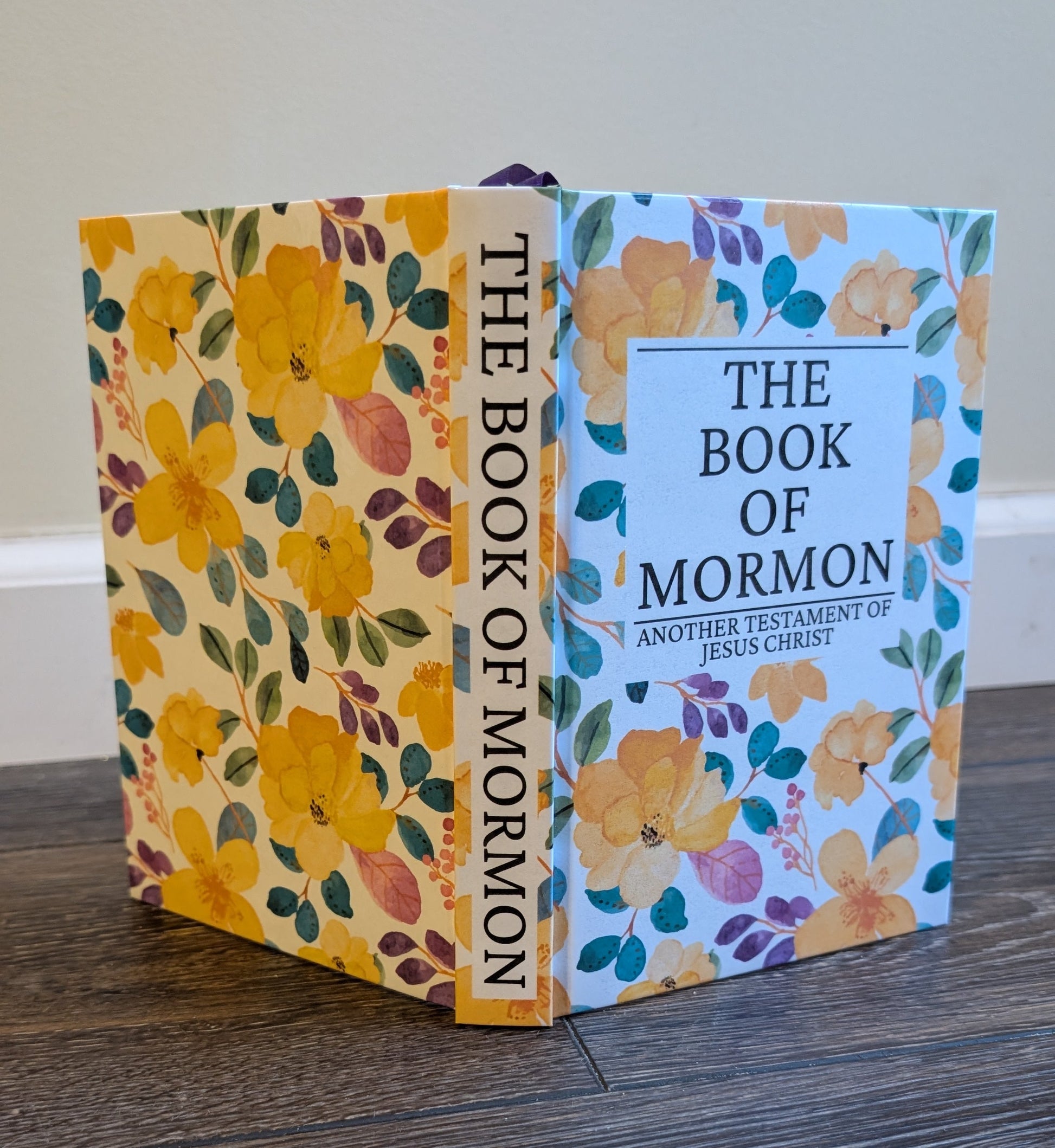 Floral-covered 'The Book of Mormon' on a wooden surface