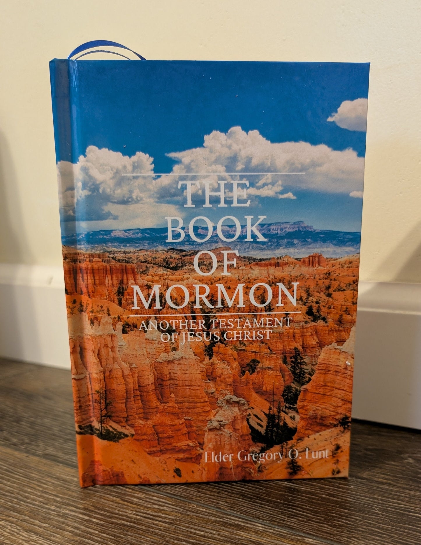 Book of Mormon on a wooden surface with a scenic cover featuring the grand canyon.
